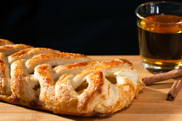 Pie and apple juice on black background