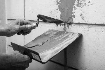 Skillful Old Man Plasterer Plastering Cement on the Old Brick Wall
