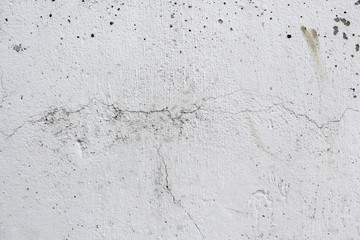 Old white wall in the cracks. Urban texture. Old damaged white plaster. Stucco wall, grungy background.