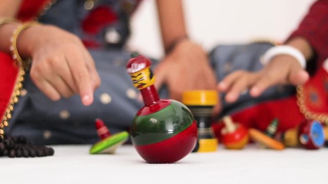 Closeup of child's hands playing with a wooden roly-poly toy doll at home.