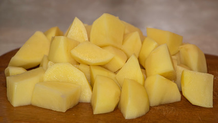 Sliced potatoes in the kitchen on a wooden background