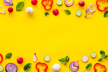Cook frame with fresh vegetables on yellow background top view space for text