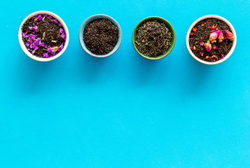 Dry leaves of herbal tea frame on blue background top view mock-up