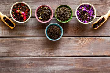 Dry leaves of herbal tea frame on wooden background top view mock up