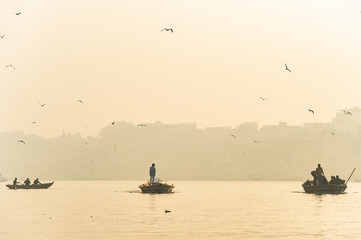 A man is sailing on his wooden boat in the sacred river Ganges in the city of Varanasi during...