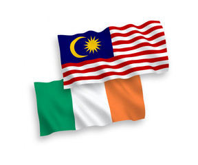 National vector fabric wave flags of Ireland and Malaysia isolated on white background. 1 to 2 proportion.