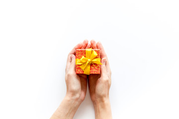 hands holding present in box on white background top view copyspace