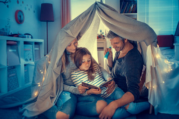 familie mit taschenlampe liest eine gruselgeschichte