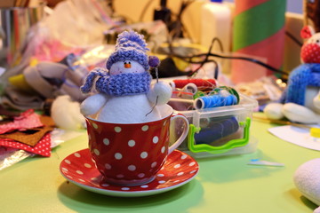 Naklejka premium Soft handmade snowman toy in a red cup with white dots. Christmas decoration
