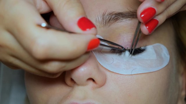 Eyelash Extension Procedure. Woman Eye with Long Eyelashes. Lashes, close up