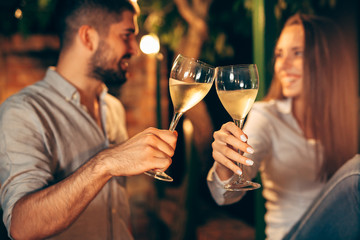 Fototapeta premium close up of romantic couple making a toast with white wine