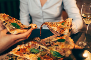 close up of people eating pizza