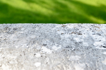 Light flat surface of stone on blurred grass background