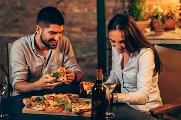 friends having hun at home eating pizza. outdoor at night