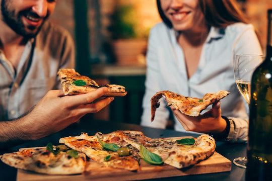 Close Up Of People Eating Pizza