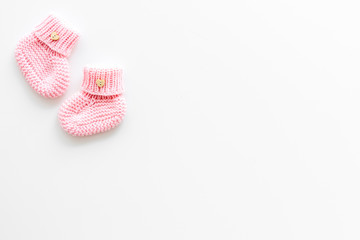 Pink knitted footwear for kids on white background top view space for text