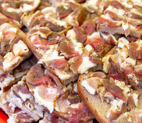 Lard with meat on bread as a background