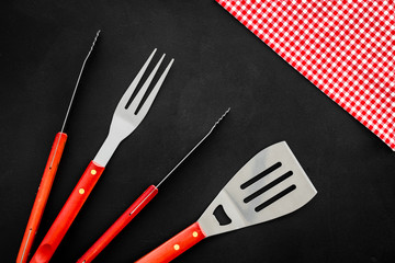 set of used barbecue tools on black background top view