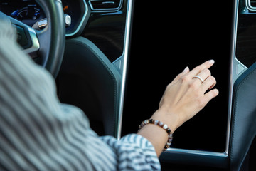 Close up of woman wearing bracelet using navigation in car