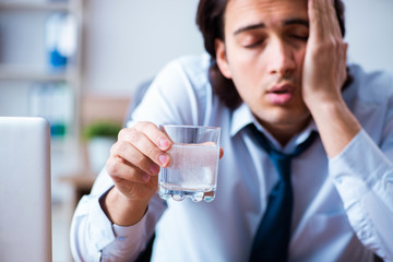 Sick male employee suffering in the office