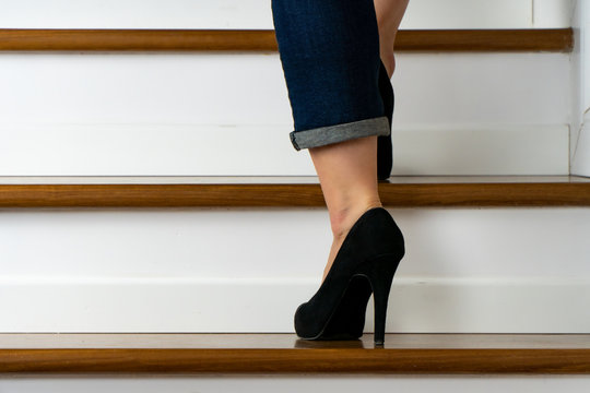 girl with heels and jeand on the stairs going up