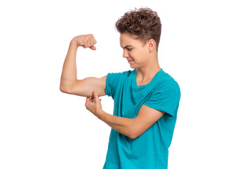 Portrait of funny teen boy raised his hands and shows biceps, isolated on white background. Handsome teenage young boy shows biceps. Happy strong child flexing biceps.