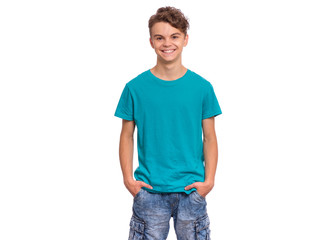 T-shirt design concept. Teen boy in blank blue t-shirt, isolated on white background. Mock up template for print. Happy child with hands in pockets looking at camera, front view.