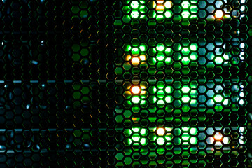 hexagonal mesh texture of metal behind which the indicator lights of the equipment