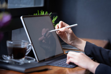 Businesswoman working with stylus and digital tablet pc at a coffee shop.