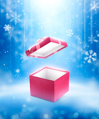Red open gift box on fallen defocused snowflakes background
