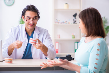 Fototapeta premium Middle-aged woman visiting male doctor stomatologist