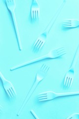 Bright neon forks on blue light background can be used as a design of children's menu. Fast food concept.