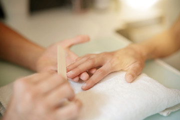 Closeup of woman's hand having manicure