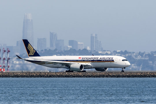 August 31, 2019 Burlingame / CA / USA - Singapore Airlines aircraft preparing for take off at San Francisco International Airport (SFO); San Francisco skyline visible in the background