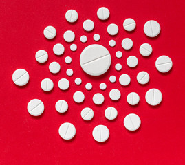 White pills on a red background