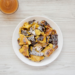Homemade german Kaiserschmarrn pancake with apple sauce on a white wooden surface, top view. Flat lay, overhead, from above.