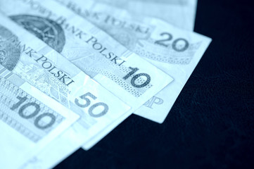 Several banknotes of Polish zloty blue color toned close up