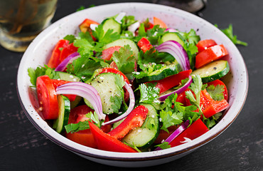 Tomato and cucumber salad with red onion, paprika, black pepper and parsley. Vegan food. Diet menu.