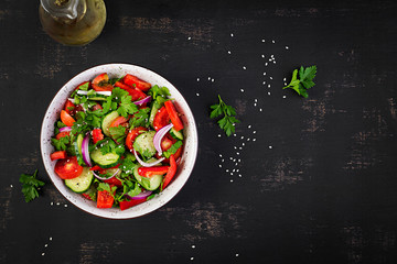 Tomato and cucumber salad with red onion, paprika, black pepper and parsley. Vegan food. Diet menu. Top view. Flat lay