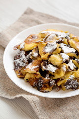 Homemade german Kaiserschmarrn pancake on a white plate, side view. Closeup.