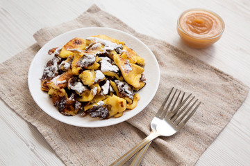 Homemade german Kaiserschmarrn pancake on a white plate, side view. Closeup.