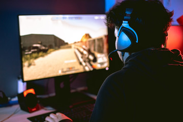 Young gamer playing video game wearing headphone. © Tawanboonnak