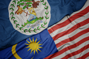 waving colorful flag of malaysia and national flag of belize.