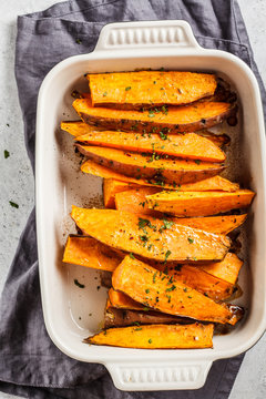 Baked Sweet Potato Slices With Spices In Oven Dish. Healthy Vegan Food Concept.