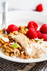 Healthy vegan breakfast - baked oatmeal crumble with berries and nut butter in a white plate.