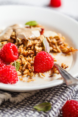 Healthy vegan breakfast - baked oatmeal crumble with berries and nut butter in a white plate.