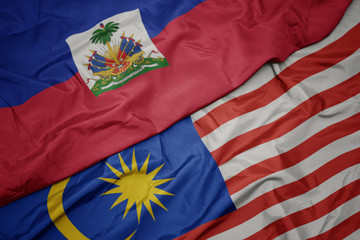 waving colorful flag of malaysia and national flag of haiti.