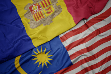 waving colorful flag of malaysia and national flag of andorra.