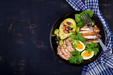 Ketogenic diet. Buddha bowl dish with meatloaf, chicken meat, avocado, berries and nuts. Detox and healthy concept. Keto food. Overhead, top view, flat lay