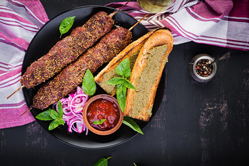Kebab adana,  lamb and beef and toasts with pesto sauce. Top view